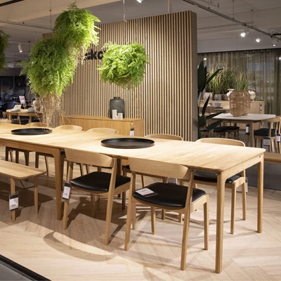 Træspisebord med stole og grønne planter i Skovby Showroom