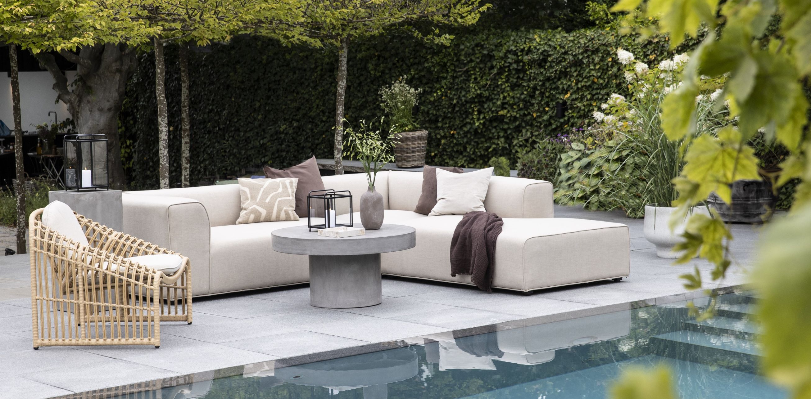 Loungesofa i lys quick dry foam tekstil placeret ved pool og lounge lænestol