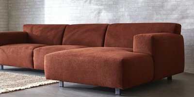 Design uden navn - 2024-12-27T222537.490.jpg Rød chaiselongsofa stående på betongulv