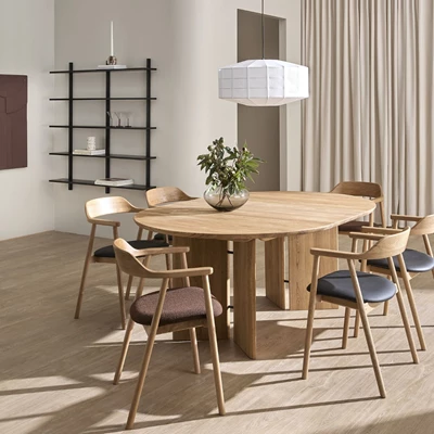 Stilfuldt spiseområde med sort Bondi reol, rundt træbord og designstole i en lys indretning