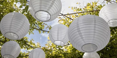 Solarix.jpg Solcellelamper i papir hængende i træ