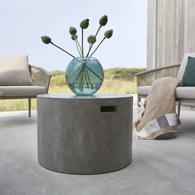 Rundt loungebord i grå fibercement med vase ovenpå