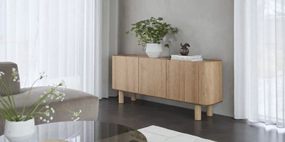 Minimalistisk stue med betongulv og lys skænk i træ