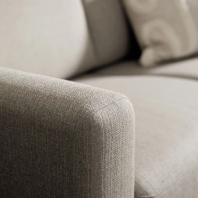 Nærbillede af armlæn på beige sofa