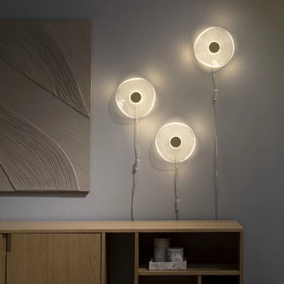 3 LED væglamper i akryl hængende på væg over skænk i træ