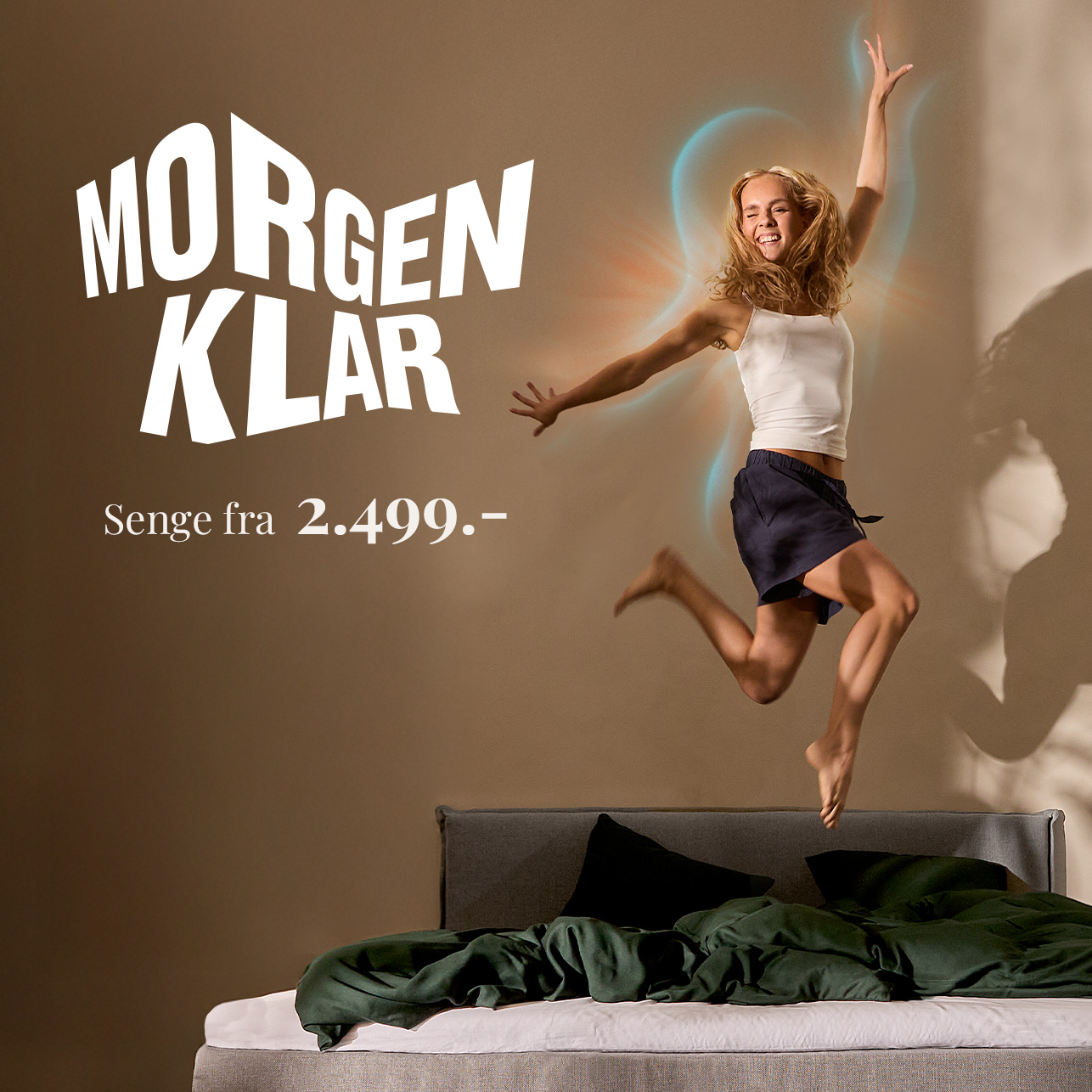 Annonce med teksten "Morgenklar" og en kvinde, der hopper glad på en seng. Senge fra 2.499 kr
