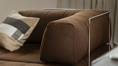 Nærbillede af armlæn på brun sovesofa